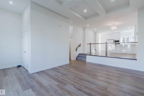 Wood-finish flooring throughout, recessed ceiling lighting, and a glass-paneled railing - 6047 180 Avenue Nw, Edmonton, AB 