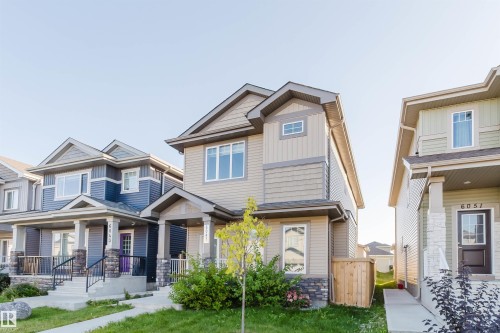 Two-story residence featuring composite siding, a covered entry, and an integrated garage - 6047 180 Avenue Nw, Edmonton, AB 