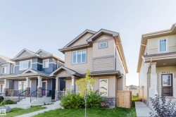 Two-story residence featuring composite siding, a covered entry, and an integrated garage - 