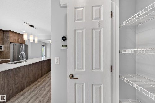 Kitchen featuring wood-finish cabinetry, stainless steel appliances, a white countertop, and a built-in sink - #44 3025 151 Av Nw, Edmonton, AB 