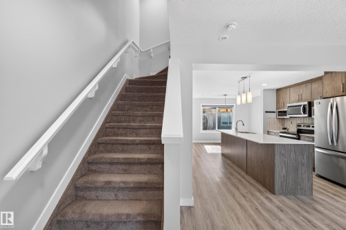 Carpeted staircase with white handrails - #44 3025 151 Av Nw, Edmonton, AB 