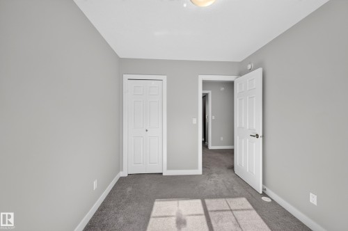 Neutral paint color, gray carpeting, white trim, white paneled doors, and ceiling-mounted light fixture - #44 3025 151 Av Nw, Edmonton, AB 
