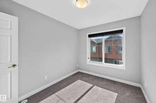 Neutral gray walls, dark carpet flooring, white trim, and a flush mount ceiling light - #44 3025 151 Av Nw, Edmonton, AB 