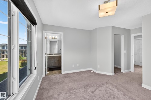 Plush carpet flooring complemented by a contemporary ceiling light fixture - #44 3025 151 Av Nw, Edmonton, AB 