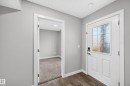 Modern entry door with privacy glass panel and dark wood-finish flooring - #44 3025 151 Av Nw, Edmonton, AB 