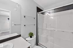 Walk-in shower with black subway tile surround, clear glass enclosure, and built-in seating - 