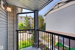 Private balcony featuring a black metal railing and textured exterior siding - 