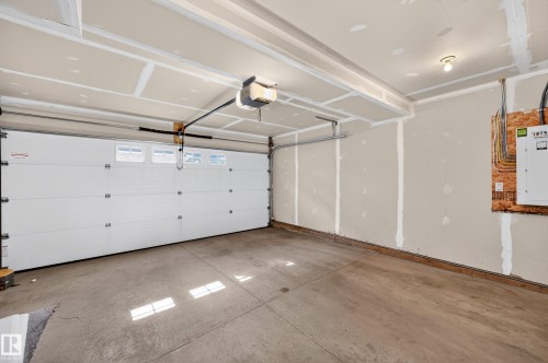 Concrete flooring, exposed ceiling beams, overhead lighting, and an automatic garage door opener - #44 3025 151 Av Nw, Edmonton, AB 