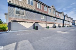 Multi-level townhome featuring horizontal siding, multiple windows, and an attached garage with an overhead door - 