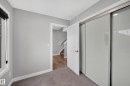 Window with black roller blind, solid core door, sliding closet doors, and light gray wall paint - #44 3025 151 Av Nw, Edmonton, AB 