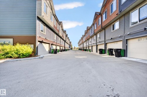 Row of townhomes featuring attached garages, multi-level construction, and mixed siding exteriors - #44 3025 151 Av Nw, Edmonton, AB 