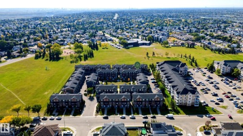 Townhome development featuring multiple units with dark shingle roofs, brick and siding exteriors, and individual driveways - #44 3025 151 Av Nw, Edmonton, AB 
