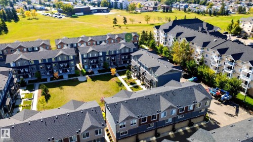 Modern townhome community featuring multi-story units with private balconies, dark shingle roofs, and light-toned siding - #44 3025 151 Av Nw, Edmonton, AB 