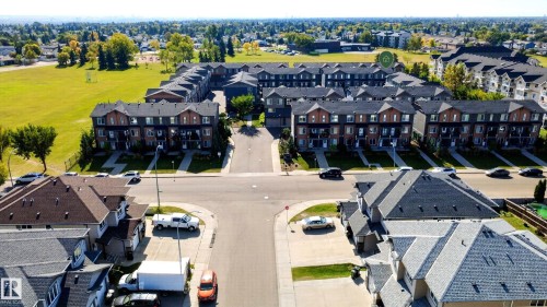Aerial perspective showcasing a residential community with multi-level townhomes and detached residences - #44 3025 151 Av Nw, Edmonton, AB 