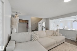 Open concept living area with wood-finish flooring, recessed lighting, and a built-in breakfast bar - 