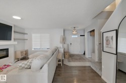 Wood-finish flooring, recessed lighting, and built-in fireplace with floating shelving - 