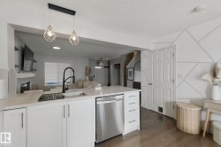 Kitchen island featuring a single-basin sink, black gooseneck faucet, and stainless steel dishwasher - 