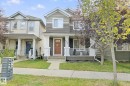 Two-story residence featuring a covered front porch, white railing, and a welcoming front door - 8535 Ellis Link Link Nw, Edmonton, AB 