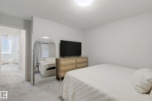Recessed lighting, light-colored walls, and textured carpeting create an inviting atmosphere - 8535 Ellis Link Link Nw, Edmonton, AB 