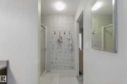 Glass-enclosed shower with a sliding door, tile flooring, and a flush-mount ceiling light fixture - 