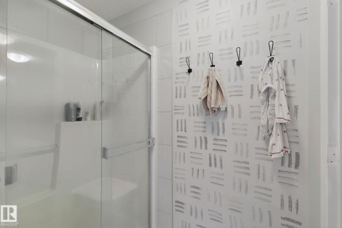 Shower enclosure with sliding glass doors and an integrated shelving niche - 8535 Ellis Link Link Nw, Edmonton, AB 