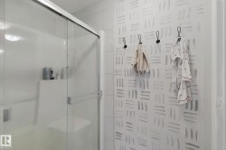 Shower enclosure with sliding glass doors and an integrated shelving niche - 