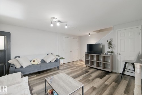 Wood-finish flooring, recessed lighting, track lighting, and a paneled door - 8535 Ellis Link Link Nw, Edmonton, AB 