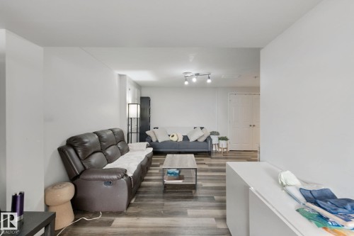 Wood-finish flooring throughout, track lighting, and a neutral wall palette - 8535 Ellis Link Link Nw, Edmonton, AB 