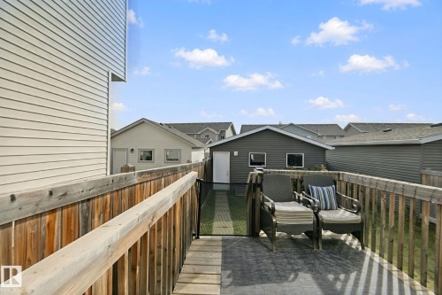 Wood-finish deck with a built-in privacy screen, featuring a rear detached garage and durable siding - 8535 Ellis Link Link Nw, Edmonton, AB 