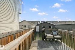Wood-finish deck with a built-in privacy screen, featuring a rear detached garage and durable siding - 