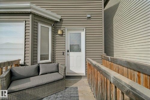 Outdoor deck with wood railings and a white entry door - 8535 Ellis Link Link Nw, Edmonton, AB 