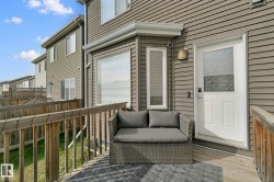 Private deck with wooden railings, vinyl siding exterior, and a white entry door with frosted glass - 