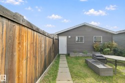 Expansive backyard featuring a wood privacy fence and a detached garage with horizontal siding - 