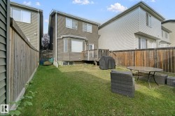 Backyard featuring a wooden deck with railing, a bay window, and a privacy fence - 