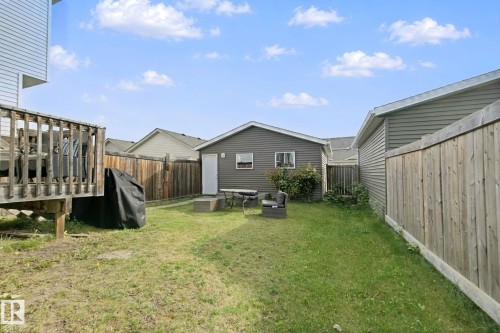 Expansive backyard with a wood deck, detached garage, and wood privacy fencing - 8535 Ellis Link Link Nw, Edmonton, AB 
