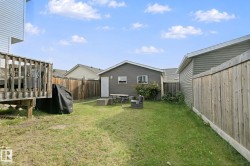 Expansive backyard with a wood deck, detached garage, and wood privacy fencing - 