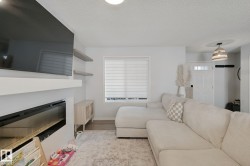 Built-in fireplace, floating shelves, recessed lighting, wood-finish flooring, and a decorative light fixture - 