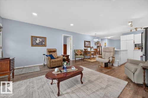 Recessed lighting, wood-finish flooring, white kitchen cabinetry, and track lighting - #125 4610 50 Ave, Stony Plain, AB 