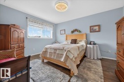 Spacious room featuring wood-finish flooring and a central ceiling light fixture - 