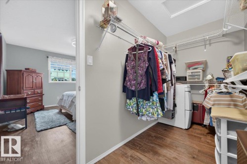 Wood-finish flooring throughout, white baseboards, and light gray walls - #125 4610 50 Ave, Stony Plain, AB 