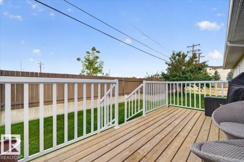 Wood-plank deck with white railings, offering outdoor living space - #125 4610 50 Ave, Stony Plain, AB 