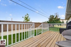 Wood-plank deck with white railings, offering outdoor living space - 