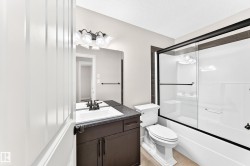 Bathroom with a dark wood-finish vanity, white rectangular sink, and a dark countertop - 