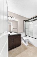 Full vanity with dark wood-finish cabinetry, integrated sink, and dark countertop - 