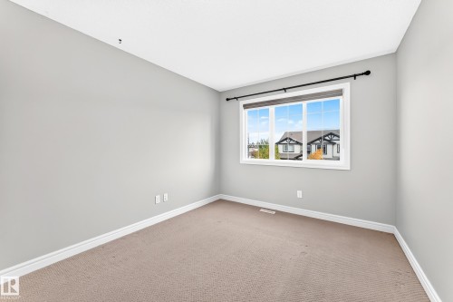 Neutral wall color, soft carpet flooring, white trim, and a large window with white framing - Edmonton, AB 