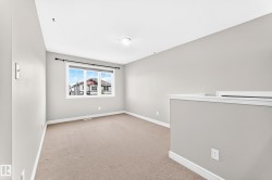 Carpeted flooring, neutral wall tones, window with multiple panes, ceiling-mounted light fixture, white trim - 
