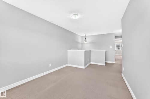 Carpeted flooring, neutral wall tones, white trim, recessed lighting, and a contemporary pendant fixture - Edmonton, AB 
