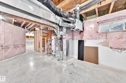 Unfinished basement with exposed ceiling joists, concrete flooring, and an installed HVAC system - 