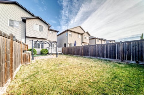 Expansive fenced backyard featuring a patio, pergola, and grassy area - Edmonton, AB 