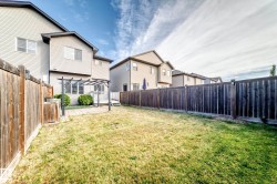 Expansive fenced backyard featuring a patio, pergola, and grassy area - 